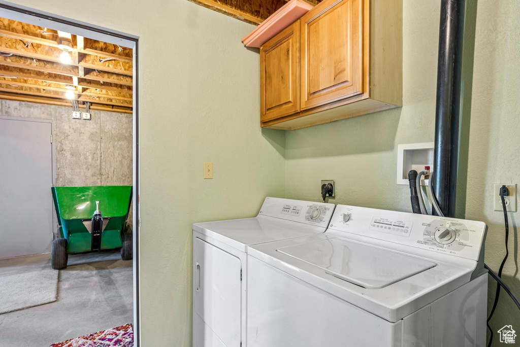 Laundry area featuring cabinet space and washer and clothes dryer