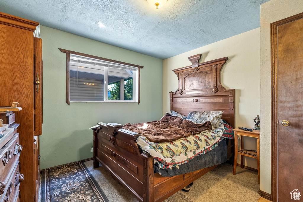 Bedroom with a textured ceiling and carpet floors