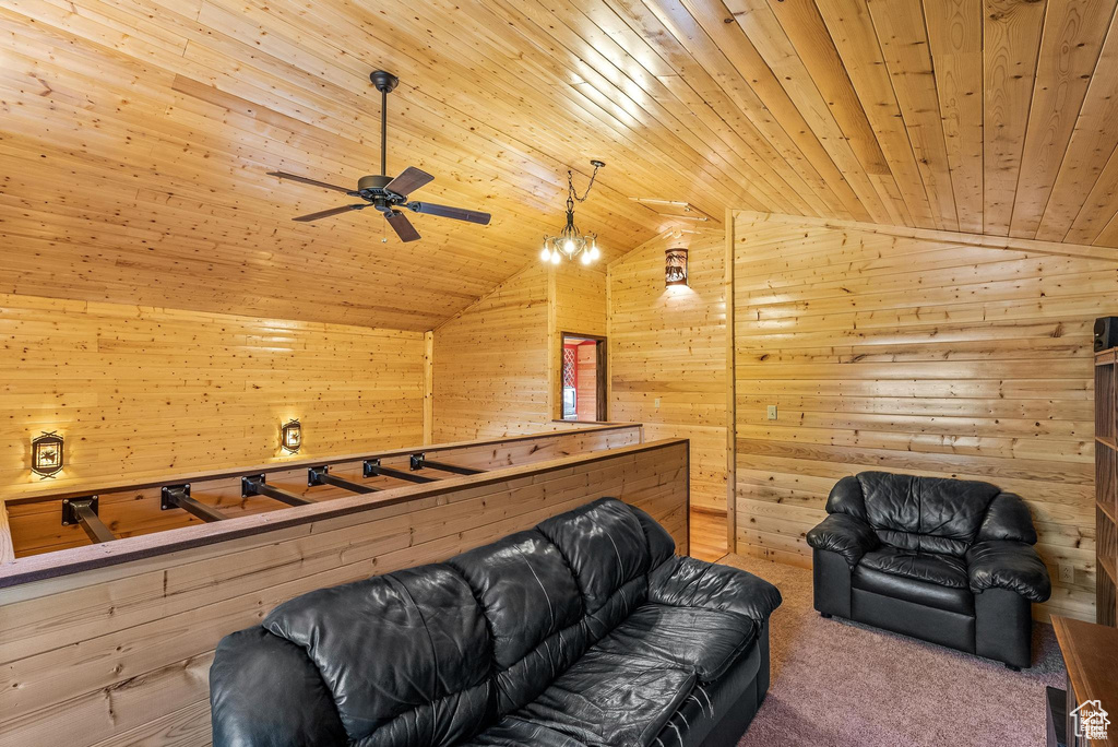Living room featuring vaulted ceiling, wood walls, ceiling fan, wood ceiling, and carpet floors