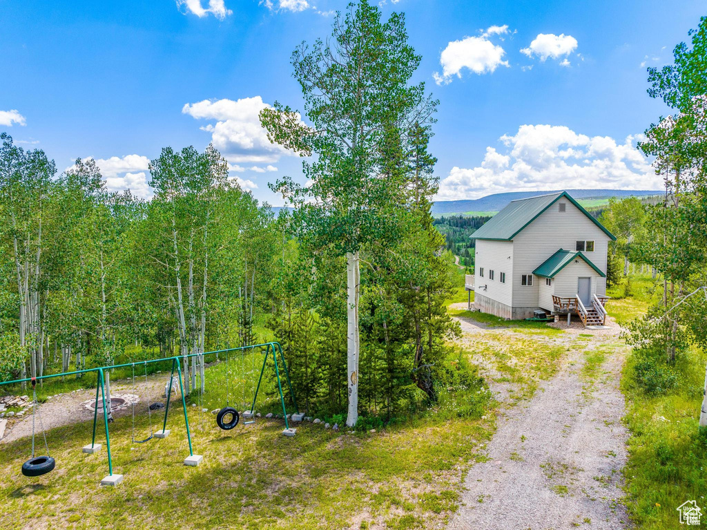 View of yard with a playground and driveway