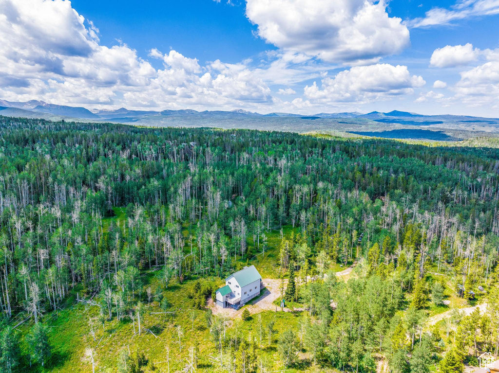 View of subject property with a forest and mountains