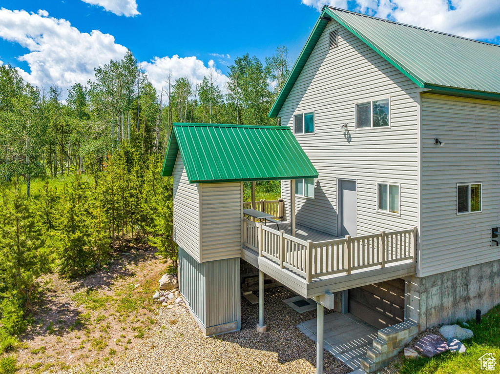 Rear view of house featuring metal roof and a deck