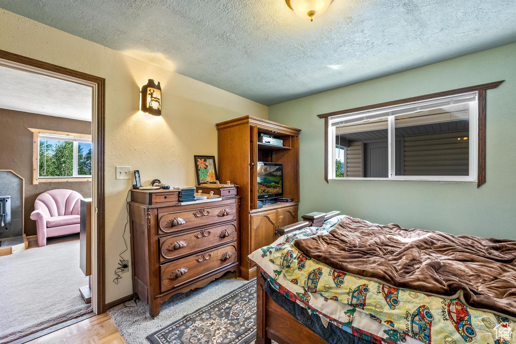 Bedroom with a textured ceiling and a textured wall