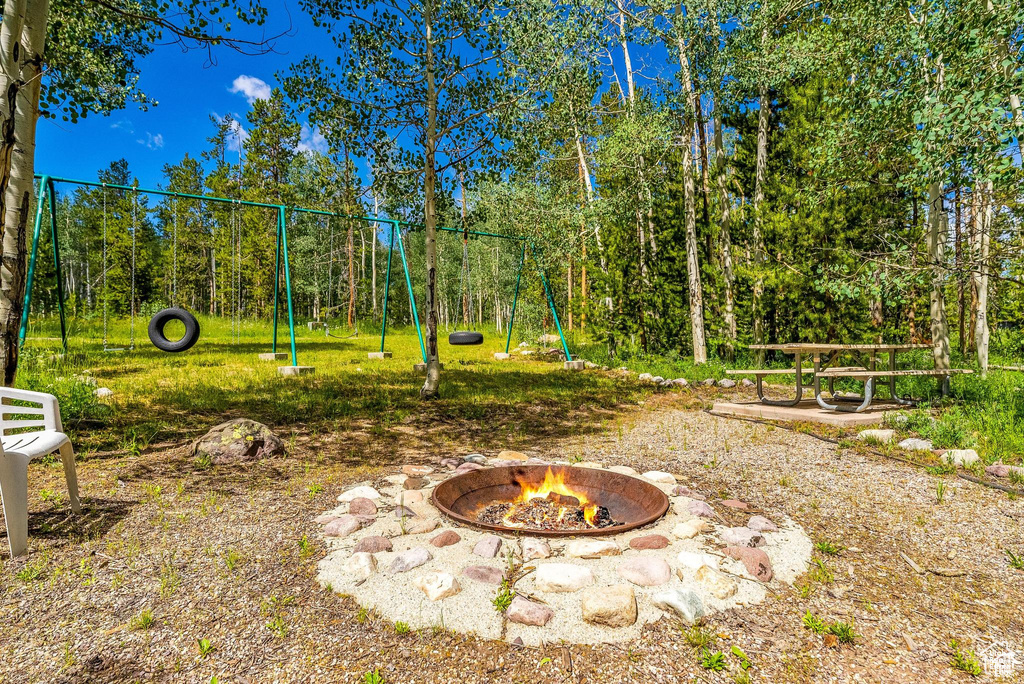 View of yard with an outdoor fire pit and a playground