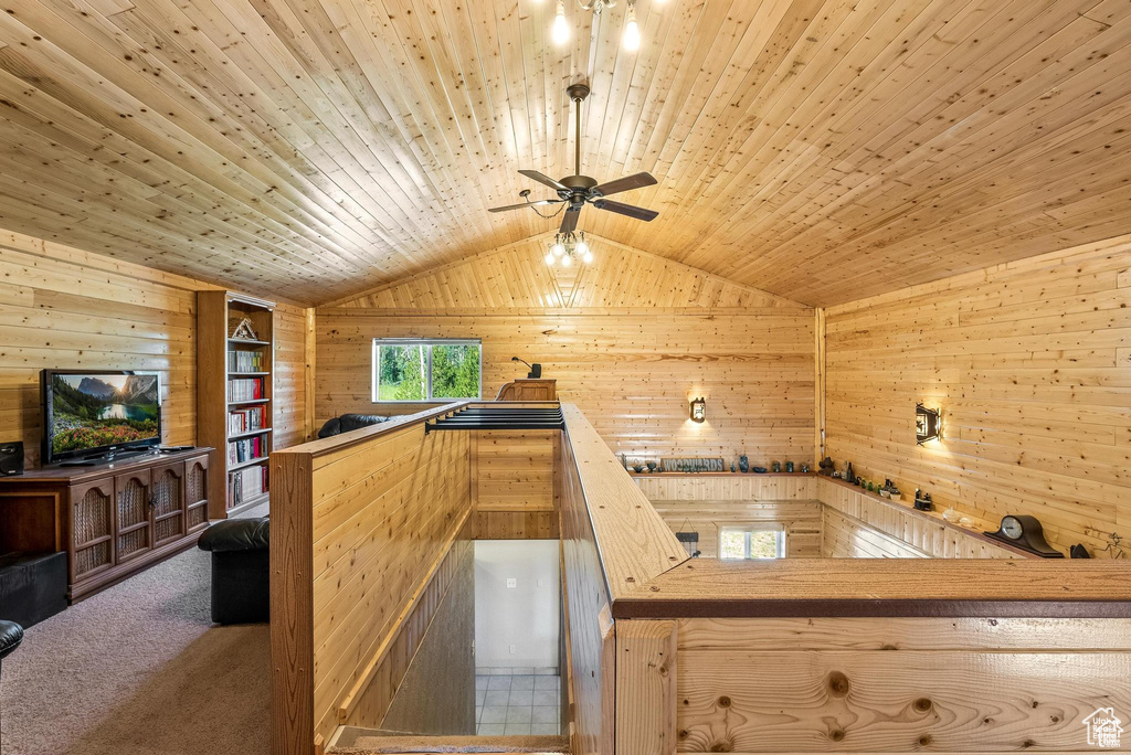 Kitchen with wood walls, lofted ceiling, a ceiling fan, carpet, and wooden ceiling