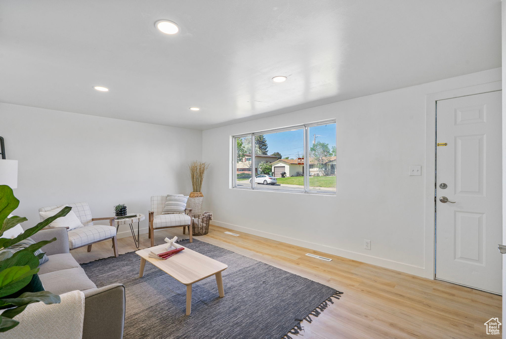 Living room featuring light wood-type flooring, baseboards, and recessed lighting