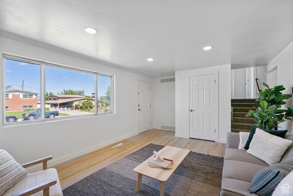 Living area with stairway, light wood-style floors, recessed lighting, and baseboards
