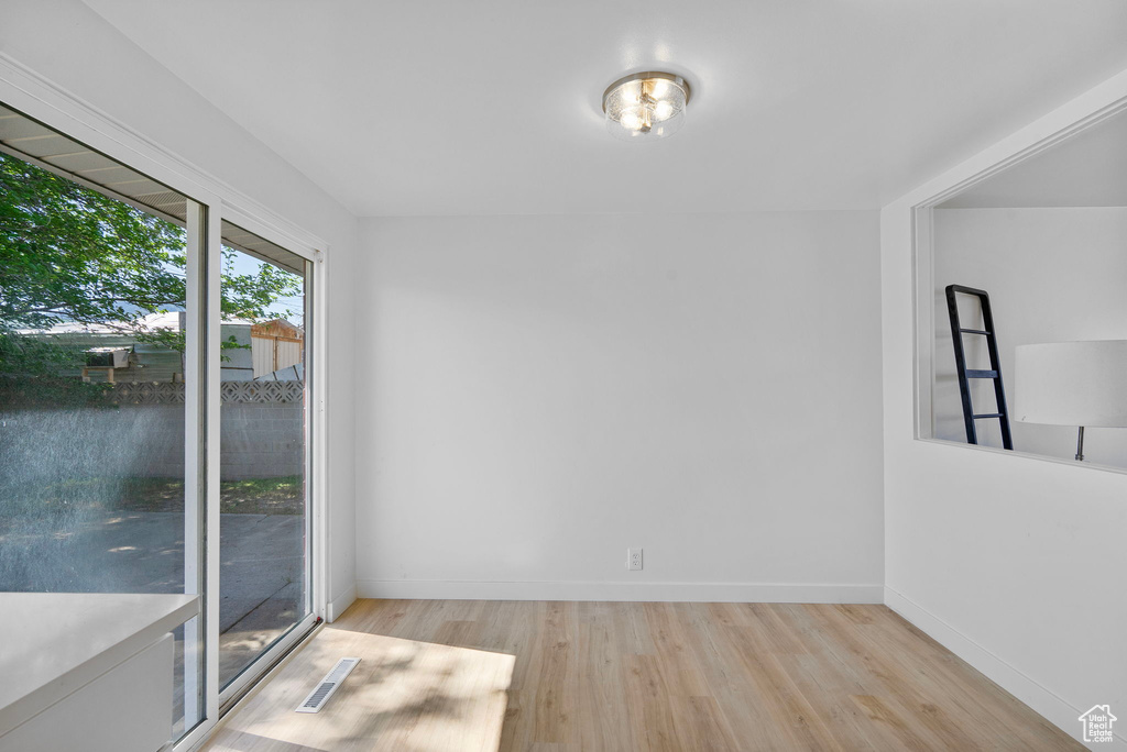 Unfurnished dining area with light wood-type flooring and baseboards
