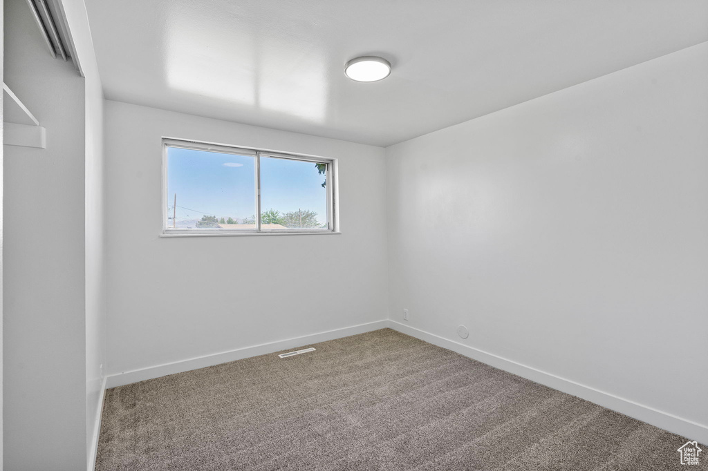 Carpeted empty room with baseboards