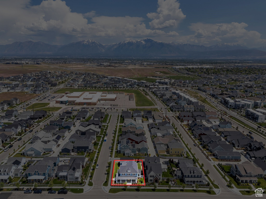 Aerial view of residential area featuring property boundaries highlighted and a mountain backdrop
