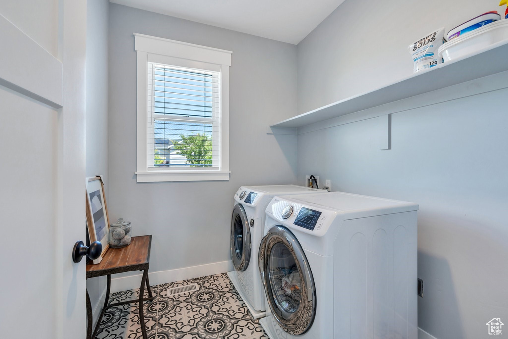 Laundry area with washer and dryer, baseboards, and light tile patterned floors