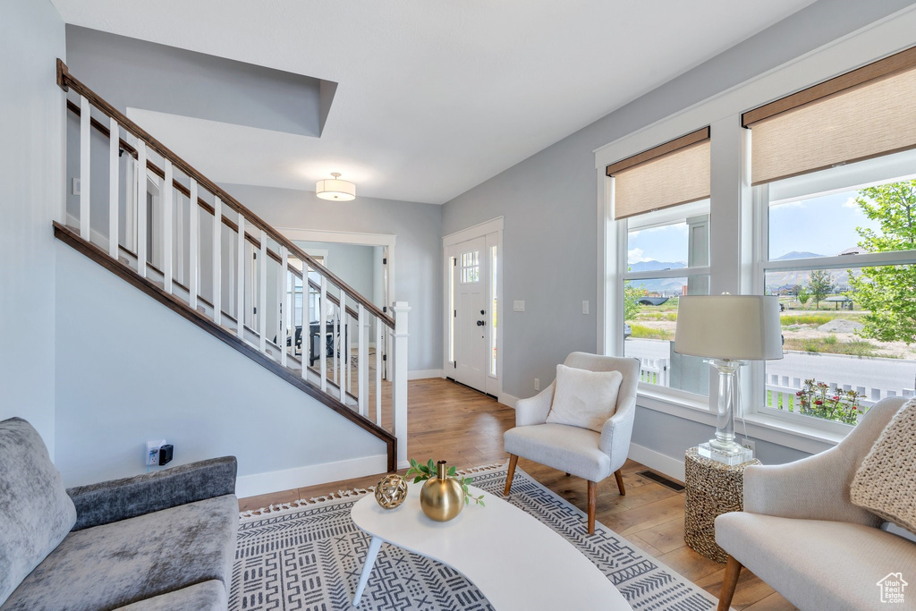 Living area featuring light wood-style floors, stairs, and baseboards