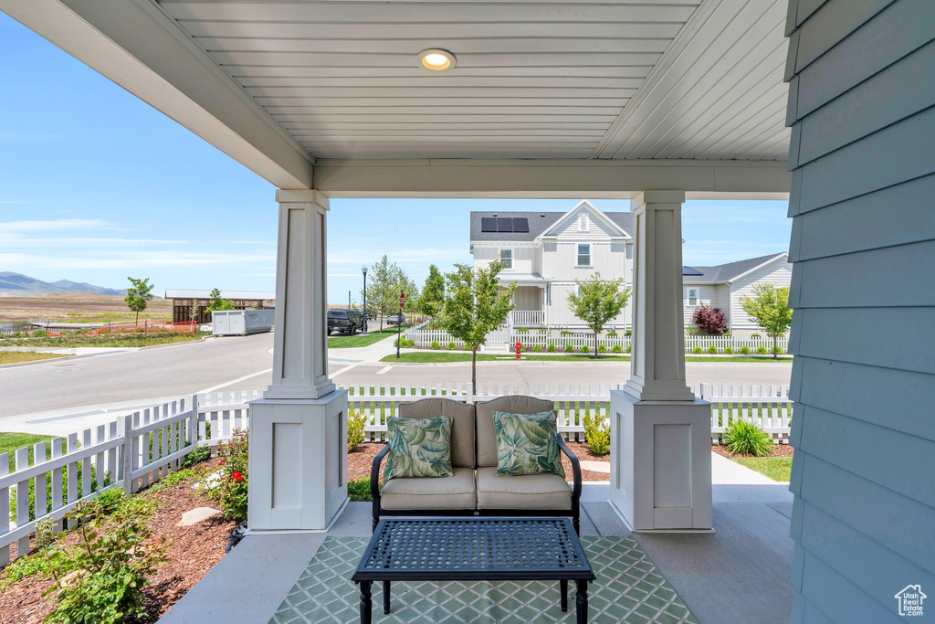 Covered porch featuring a mountain view and an outdoor living space