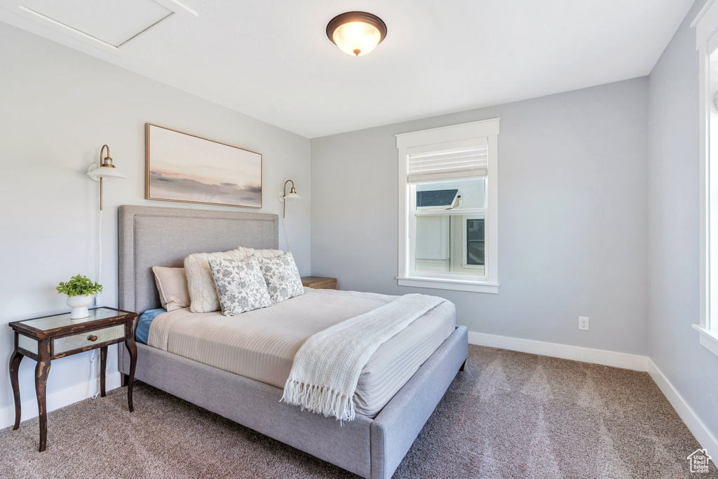 Carpeted bedroom featuring multiple windows and baseboards