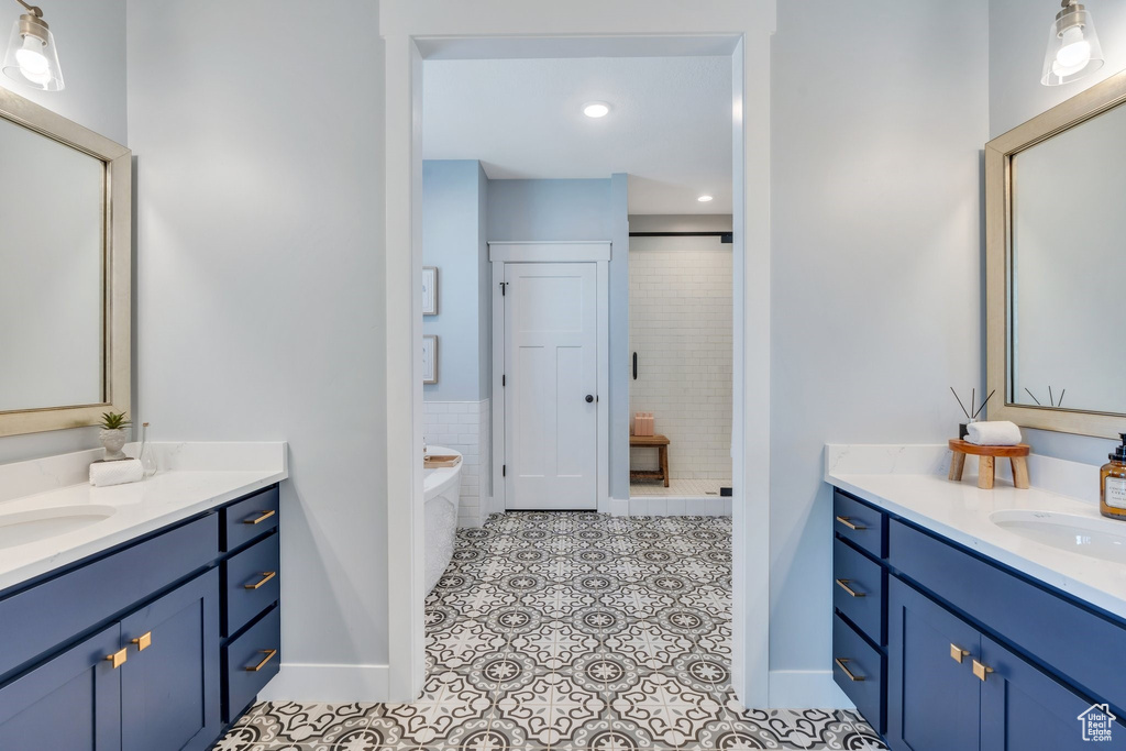 Bathroom featuring two vanities, tile patterned flooring, a shower stall, a garden tub, and recessed lighting