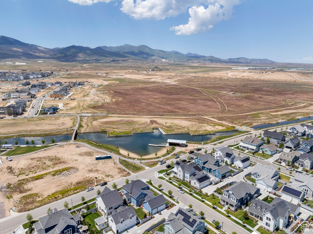 Aerial view of property and surrounding area with a water and mountain view and nearby suburban area