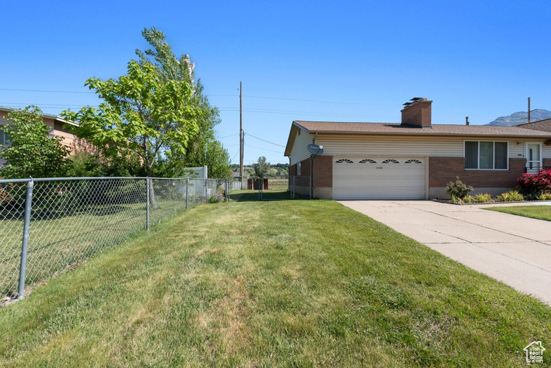 View of yard with a garage and concrete driveway