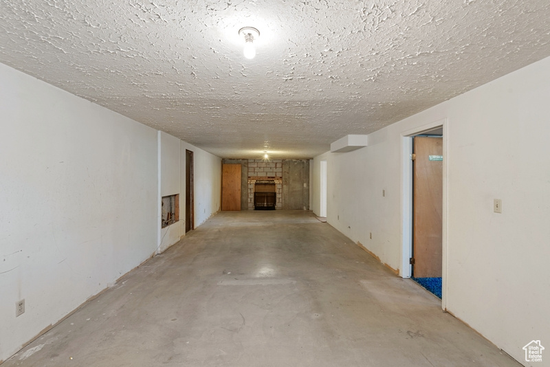 Finished basement featuring a fireplace and a textured ceiling