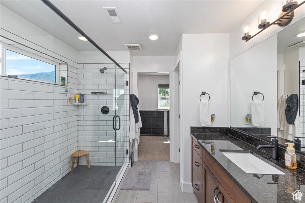 Bathroom with vanity, a stall shower, tile patterned floors, and recessed lighting