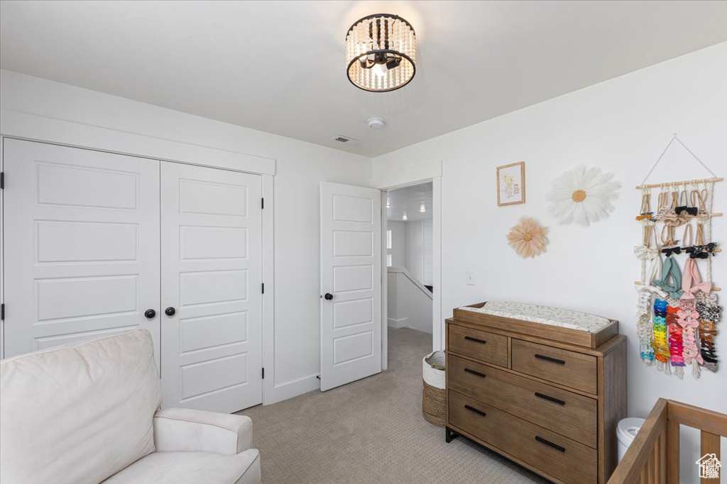Bedroom with light carpet and a closet