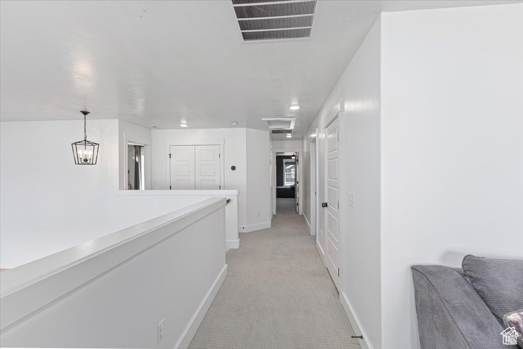 Hallway featuring baseboards and light carpet
