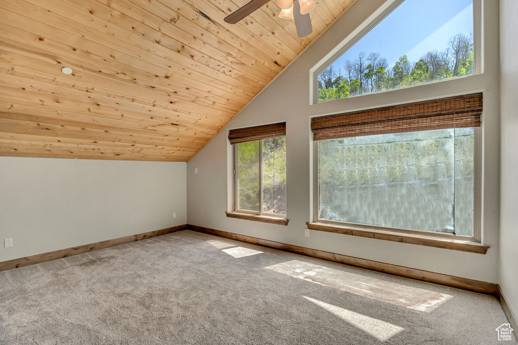 Additional living space featuring vaulted ceiling, wood ceiling, baseboards, carpet flooring, and a ceiling fan