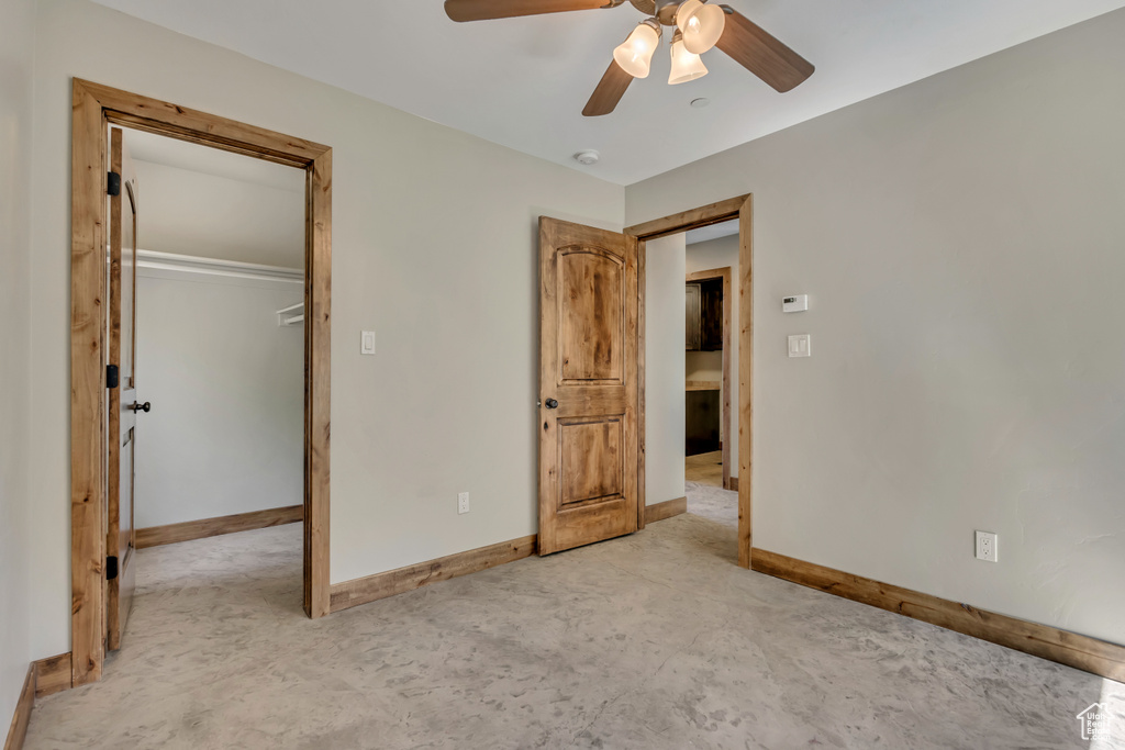 Unfurnished bedroom featuring baseboards, a closet, concrete flooring, and a ceiling fan