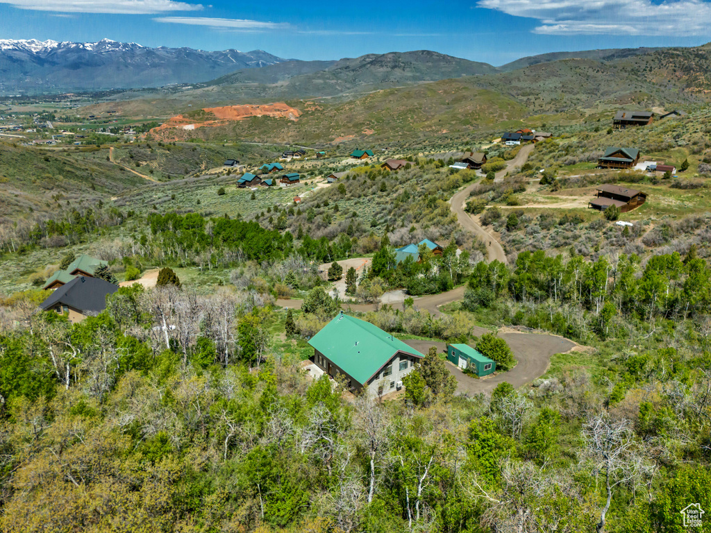 Aerial view of property and surrounding area featuring a mountainous background