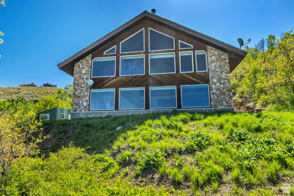 Back of property featuring stone siding