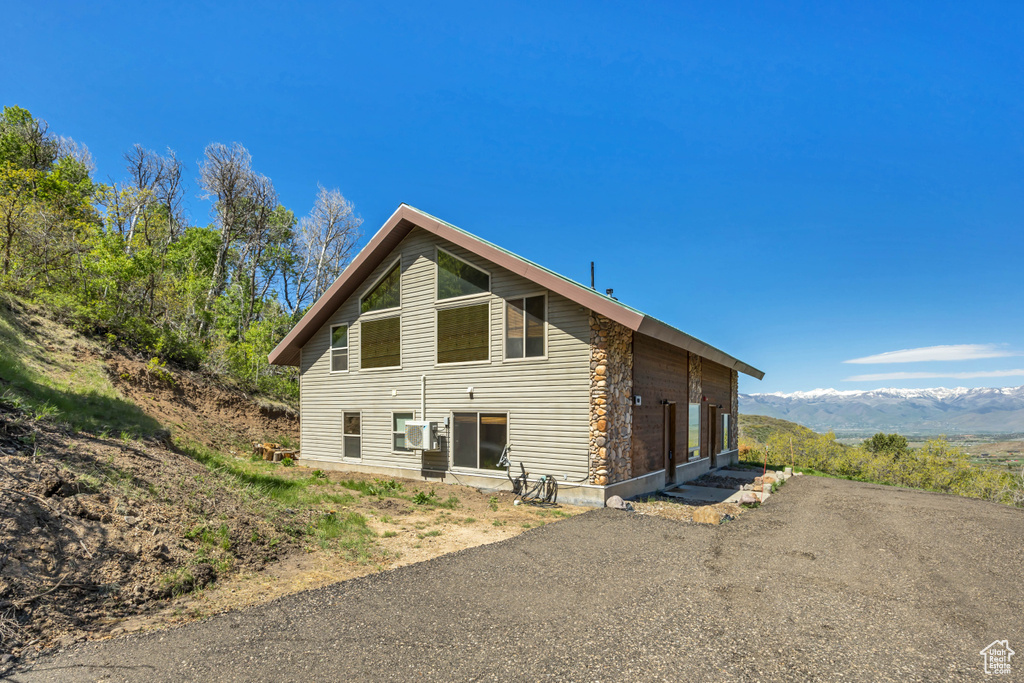 Back of house featuring cooling unit and a mountain view