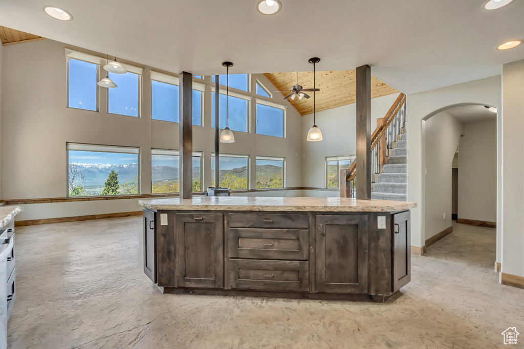 Kitchen with baseboards, dark brown cabinetry, ceiling fan, recessed lighting, and high vaulted ceiling