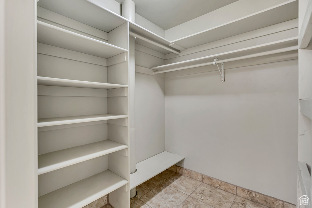 Spacious closet featuring stone finish floors