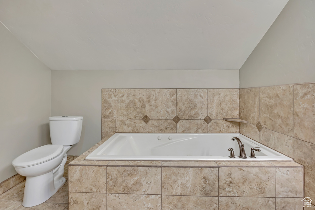Full bathroom with toilet and a garden tub
