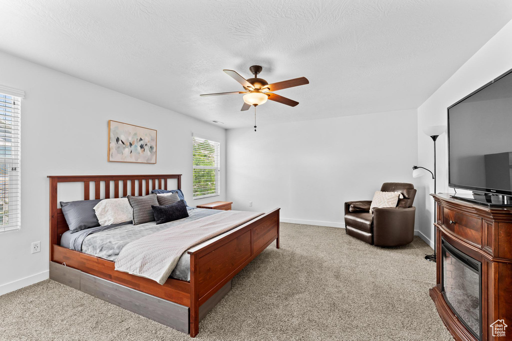 Carpeted bedroom featuring baseboards and ceiling fan