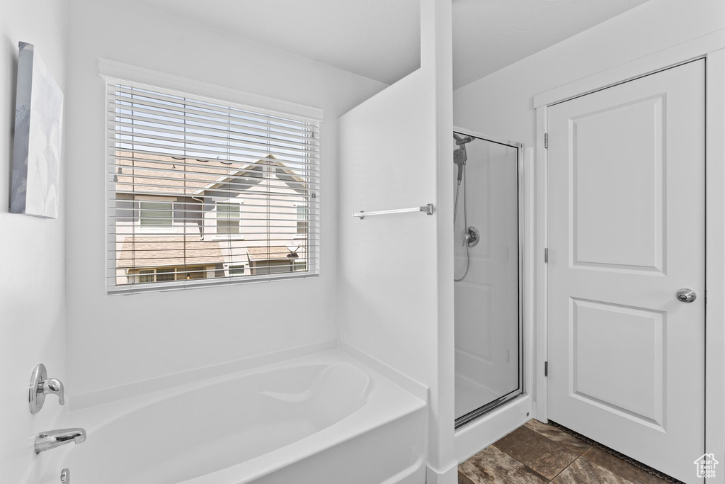 Full bathroom with a bath, a shower stall, and healthy amount of natural light