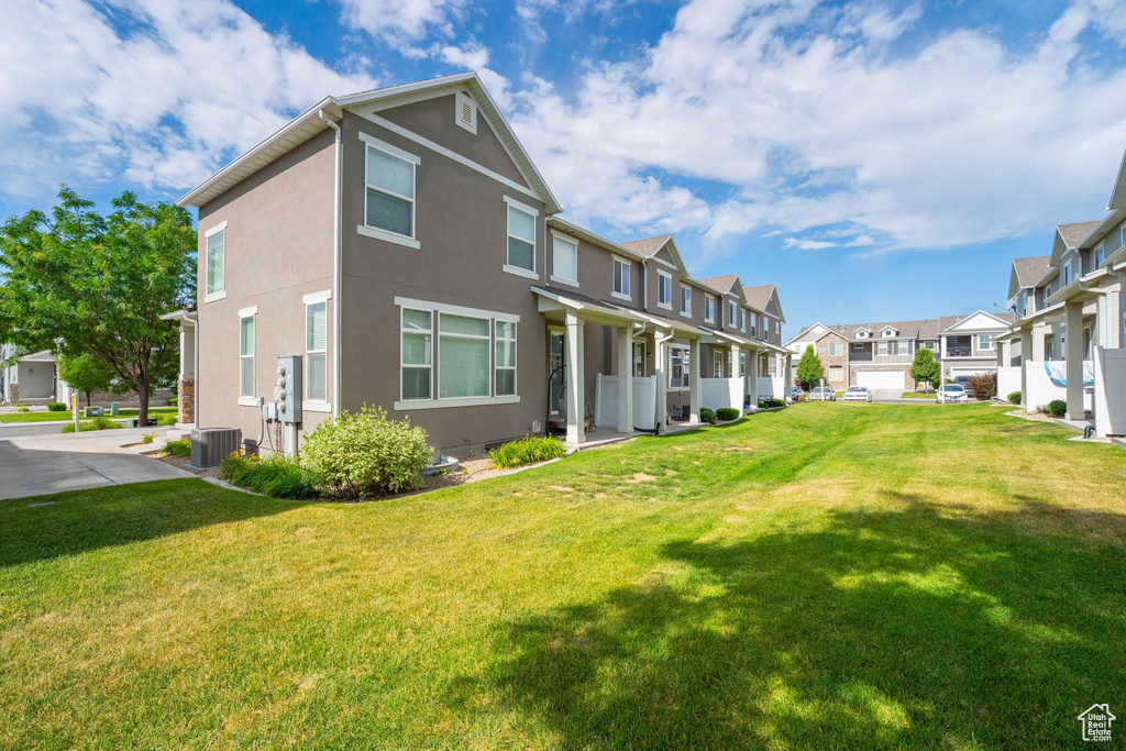 Rear view of house with a residential view, stucco siding, and a yard