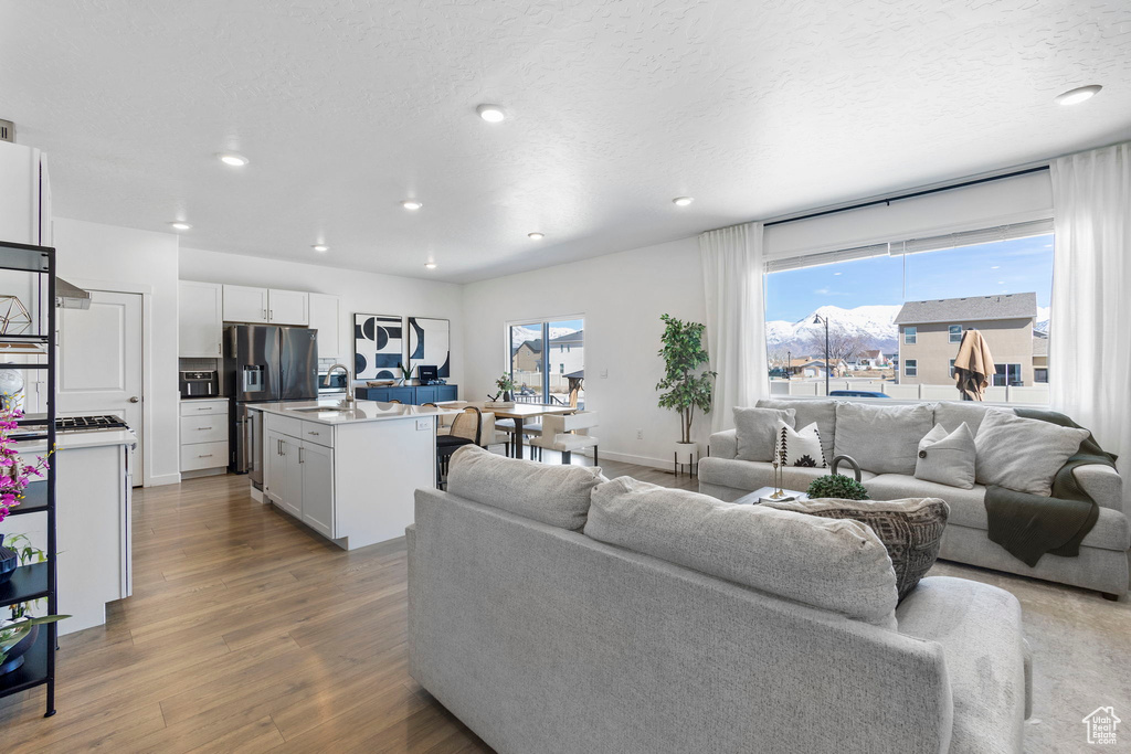 Living area with wood finished floors, recessed lighting, plenty of natural light, and a textured ceiling