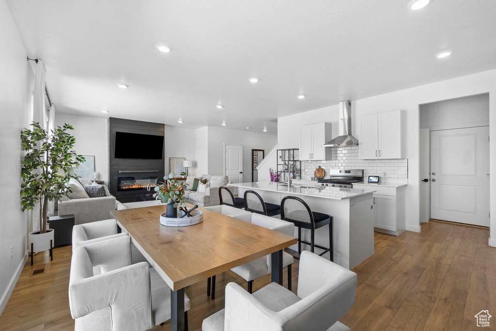 Dining area featuring recessed lighting, a large fireplace, light wood-type flooring, and baseboards