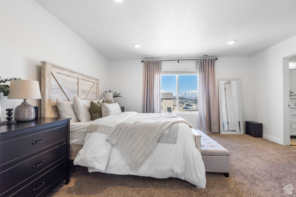 Bedroom featuring dark colored carpet, baseboards, recessed lighting, and ensuite bath