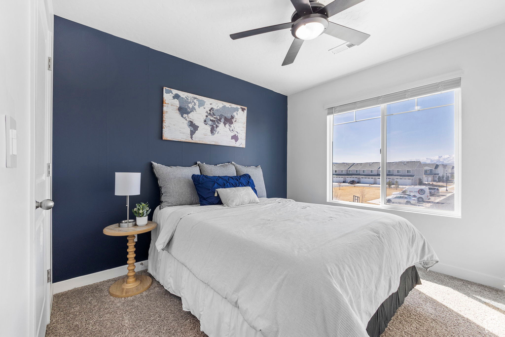 Carpeted bedroom featuring baseboards and ceiling fan