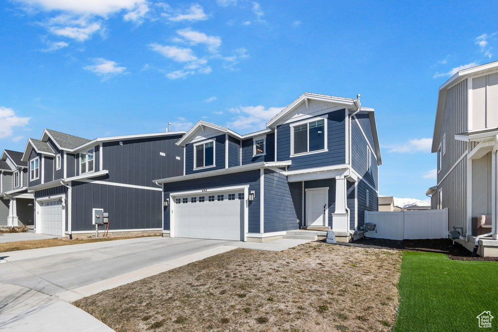 View of front of home with concrete driveway and an attached garage