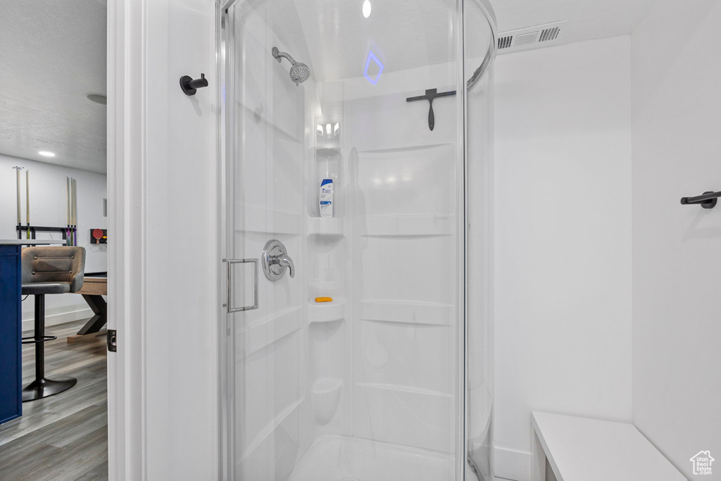 Full bathroom featuring a stall shower and wood finished floors