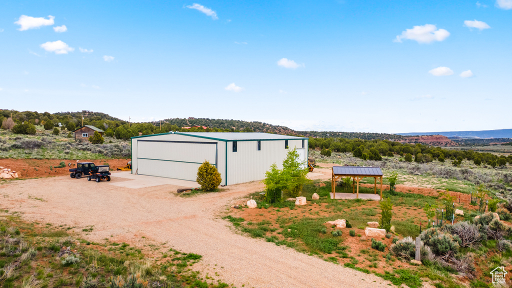 Detached garage featuring dirt driveway