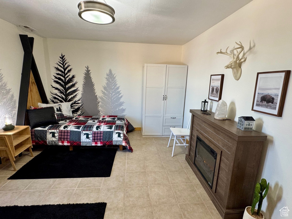 Bedroom featuring a glass covered fireplace