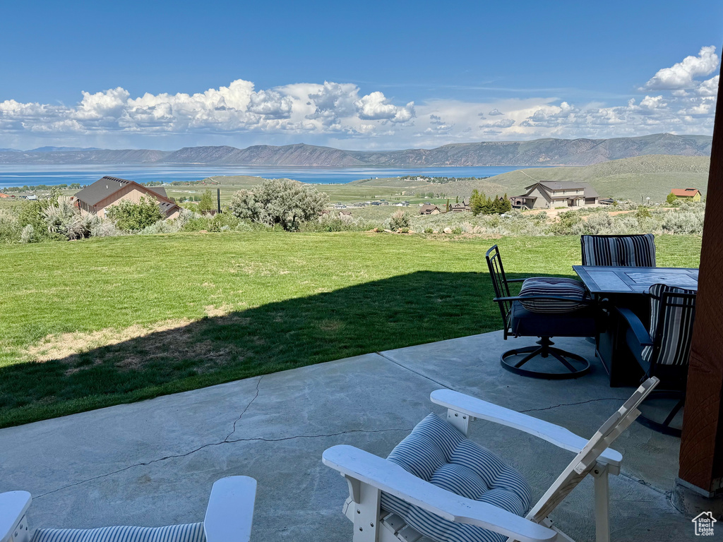 View of patio / terrace featuring a water and mountain view and outdoor dining space