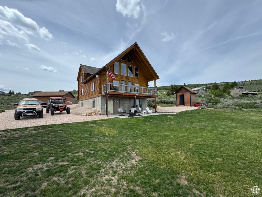 Rear view of house with a lawn and a patio area