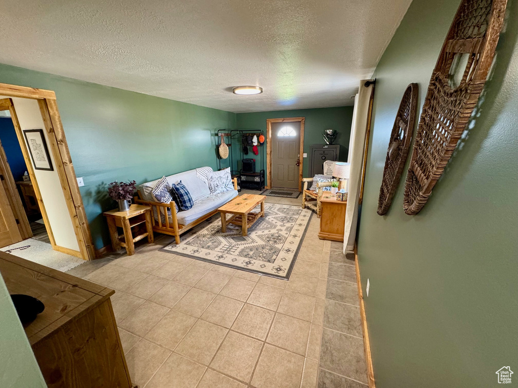 Tiled living room featuring a textured ceiling and baseboards