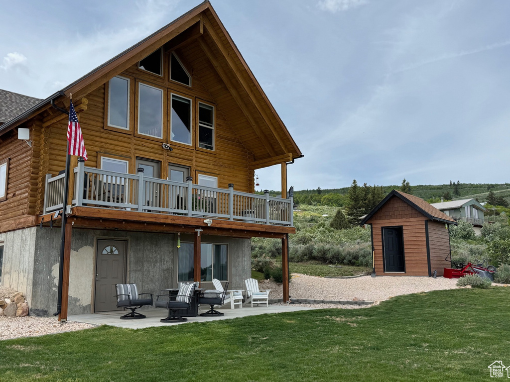 Back of property with a patio, a yard, log exterior, and a deck
