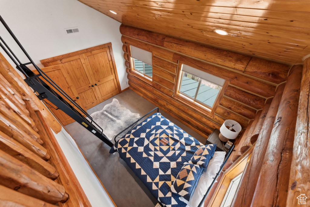 Interior space featuring rustic walls, wooden ceiling, recessed lighting, and baseboards