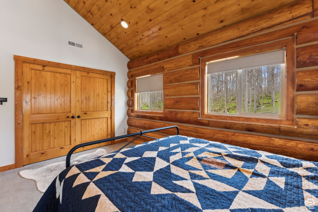 Bedroom with rustic walls, lofted ceiling, carpet floors, and wood ceiling
